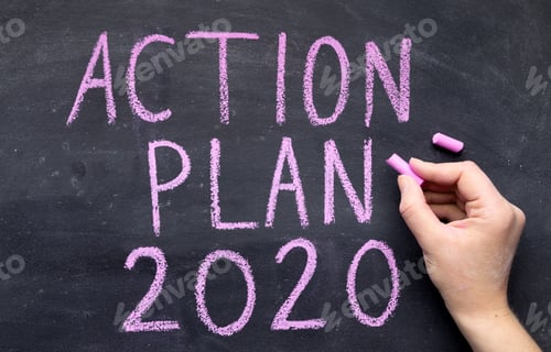Preview: Woman hand writing action plan with chalk on black board