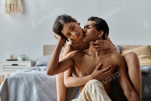Preview: Passionate interracial couple embracing on bed