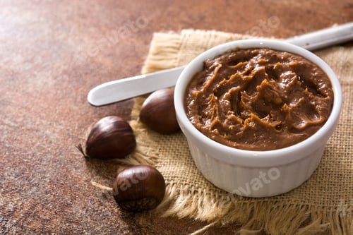 Preview: Chestnut cream in a bowl with chestnuts and knife resting on a jute tablecloth