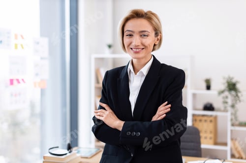 Preview: Confident businesswoman standing at desk in modern office workspace