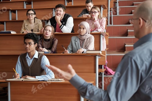 Preview: Students looking at blackboard while teacher explaining something