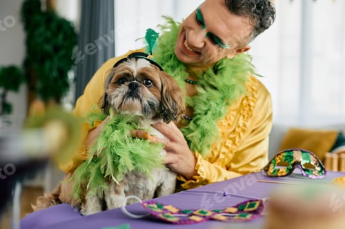 Preview: Happy man and his dog dressed up for Mardi Gras carnival.