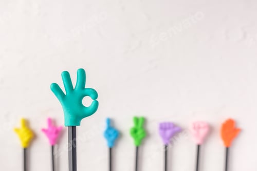 Preview: group of toy ok hand gesture on pencil with white paster concrete background