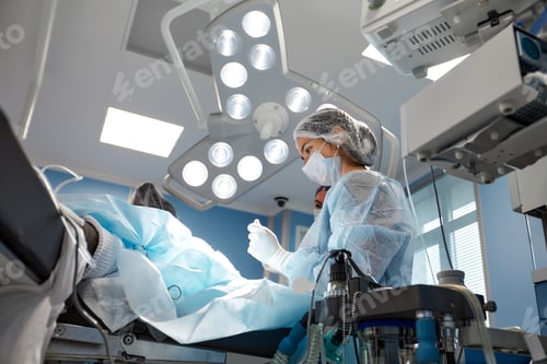 Preview: Concentrated Surgical team operating a patient in an operation theater