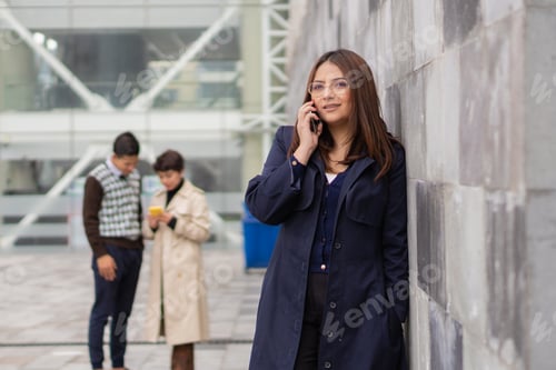 Visualização: Jovem mulher com seus colegas de trabalho em primeiro plano.