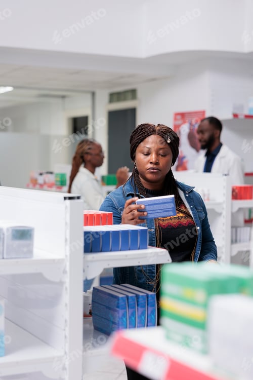 Preview: African american woman buying pills in pharmacy store