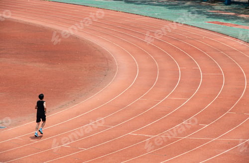 Preview: Young student is doing long-distance running exercises on the red track of a university in Wuhan