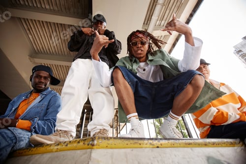 Preview: Young leader of hip hop boy band sitting on squats in front of camera