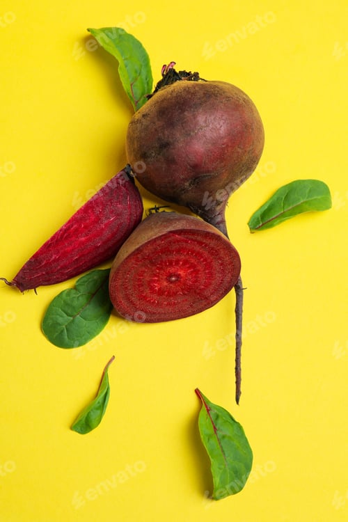 Preview: Ripe red beet with leaves on yellow background