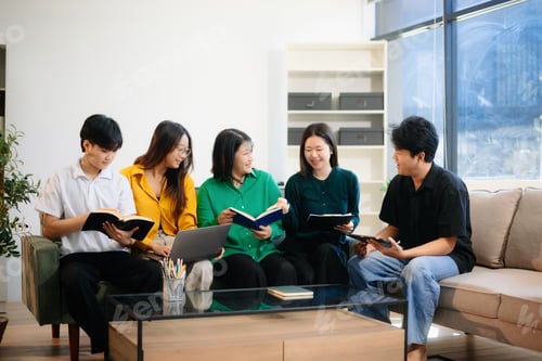 Preview: Group of young Asian students working on a project with laptops and tablets. Cozy indoor setting,