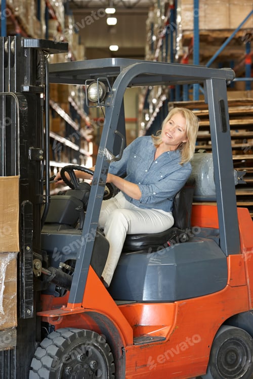 Preview: Woman Driving Fork Lift Truck In Warehouse