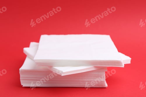 Preview: Stack of white handkerchiefs on red background, closeup
