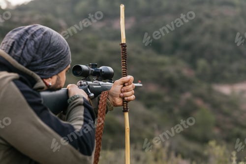 Preview: Hunter aiming with rifle scope in nature