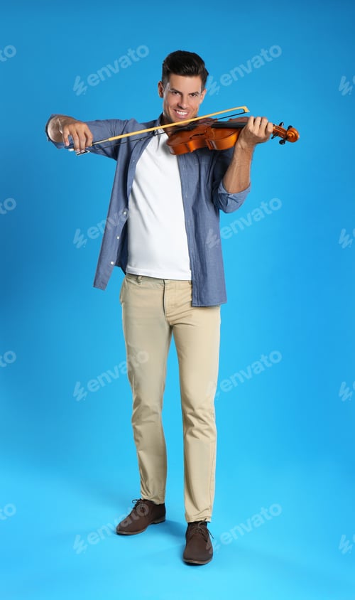 Preview: Happy man playing violin on light blue background