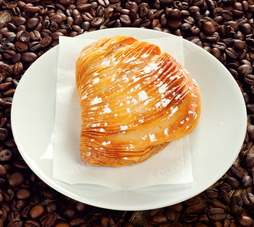 Preview: Delicious sfogliatella lying on plate with coffee beans