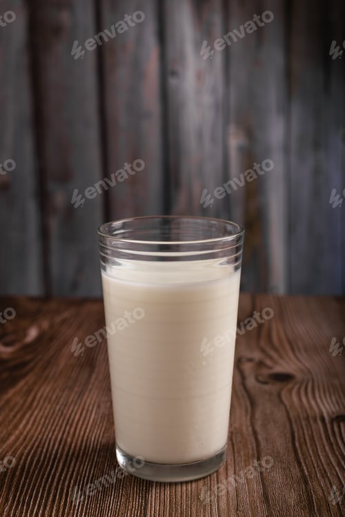 Preview: Milk glass isolated on wooden background. Copy space.