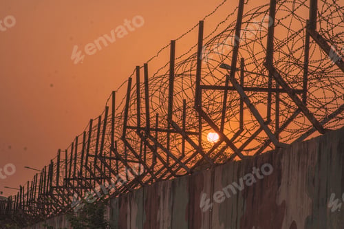 Preview: View of the prison barbed wire fence at sunset