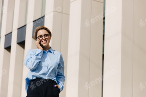 Preview: Smiling Woman Talking on Smartphone Outdoors