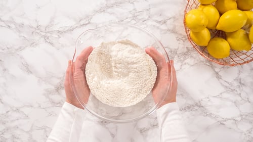 Preview: Flour in Glass Bowl Next to Fresh Lemons