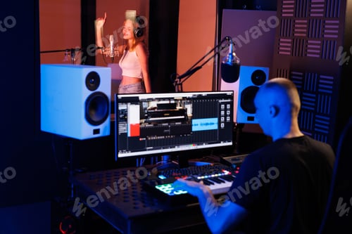 Preview: A rear view shot of a sound engineer recording in the studio and adjusting sound parameters.