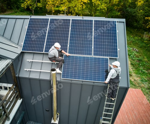 Preview: Men workers installing solar panels on roof of house.