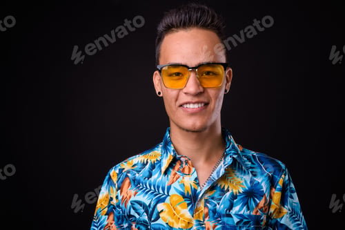 Preview: Portrait of happy young Indian tourist man with sunglasses