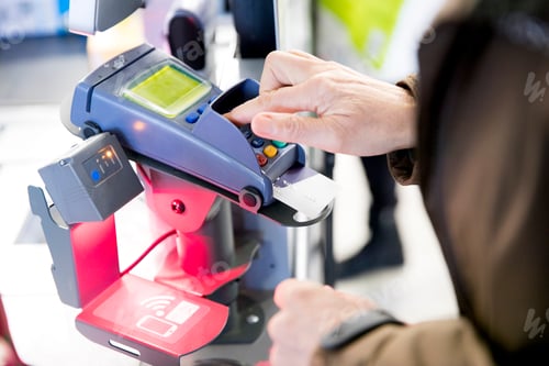 Preview: Mature woman using credit card machine to pay for shopping, close-up