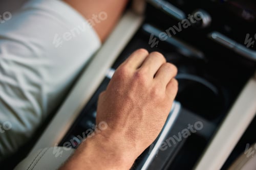 Preview: Close up of a hand adjusting the gear shift in a modern car interior