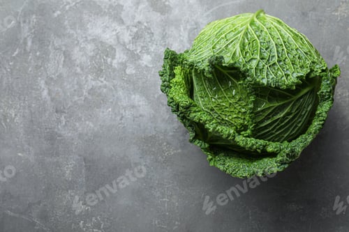 Preview: Fresh ripe savoy cabbage on grey table, top view. Space for text