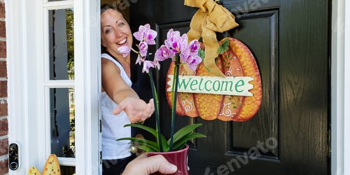 Preview: Millennial homeowner as people in fall welcomes a visitor bringing gifts to her home.