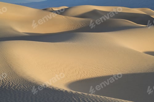 Preview: Shadows and golden light on the sand dunes at dawn abstract
