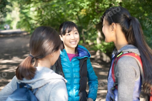 Preview: Three young female hikers chatting on country road
