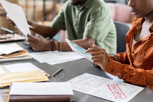 Preview: Young African female auditor pointing at tablet screen