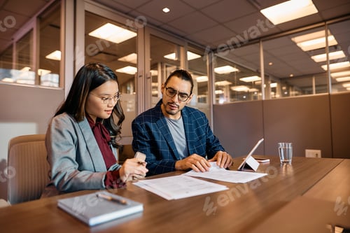 Preview: Multiracial colleagues going through business reports during the meeting in the office.