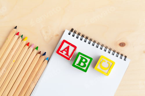 Preview: Notepad on wooden table and wood alphabet blocks