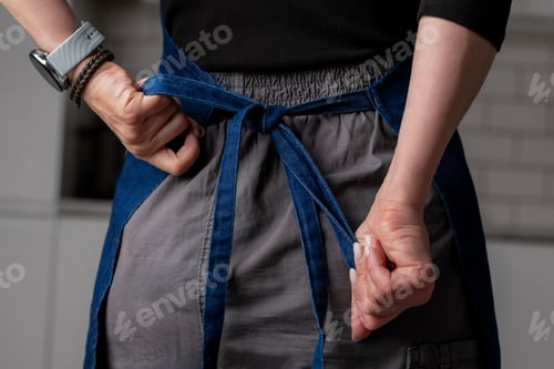 Preview: Woman'S Hands Are Tying Kitchen Apron Behind
