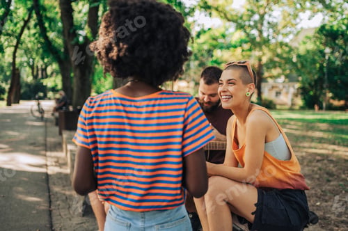 Preview: Portrait of a girl sitting with her multicultural friends in a park.