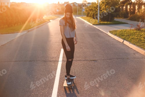 Preview: Young woman down the road with a skateboard.