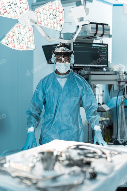 Preview: african american surgeon looking at camera in operating room