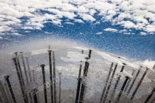 Preview: Reflection of sky and clouds in water surface of a modern fountain.