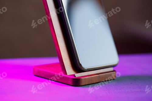 Preview: A black phone stands on a wooden stand. Wireless Charging for Phone