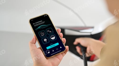 Preview: Man using EV application on phone to check charging statusใ