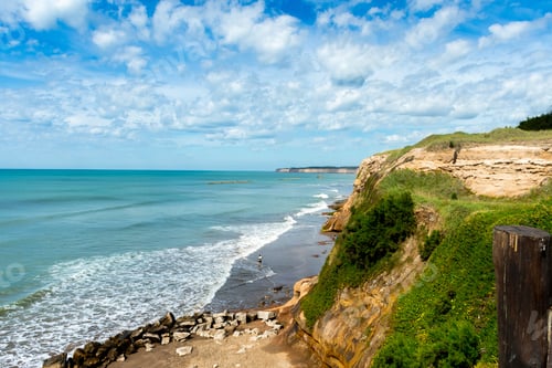 Preview: Aerial shot of wavy sea and rocky beach under cloudy sky