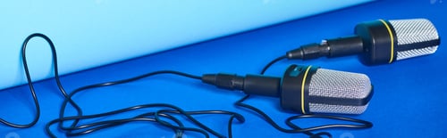 Preview: panoramic shot of black microphones with wires on colorful background