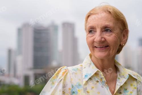 Preview: Beautiful senior woman thinking outdoors in city