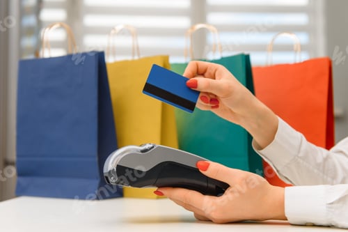 Preview: Close up of hand using credit card swiping machine to pay.
