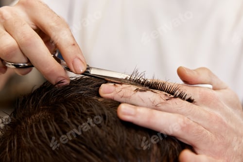 Preview: hairdresser does haircut for man using comb and grooming scissors