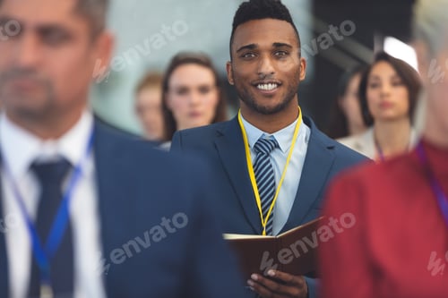 Visualização: Empresário sorrindo para a câmera em seminário de negócios em prédio de escritórios