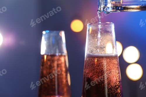 Preview: Rose champagne pouring from bottle into glass on color background, closeup. Space for text