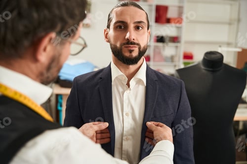 Preview: Man getting measured for a suit by tailor